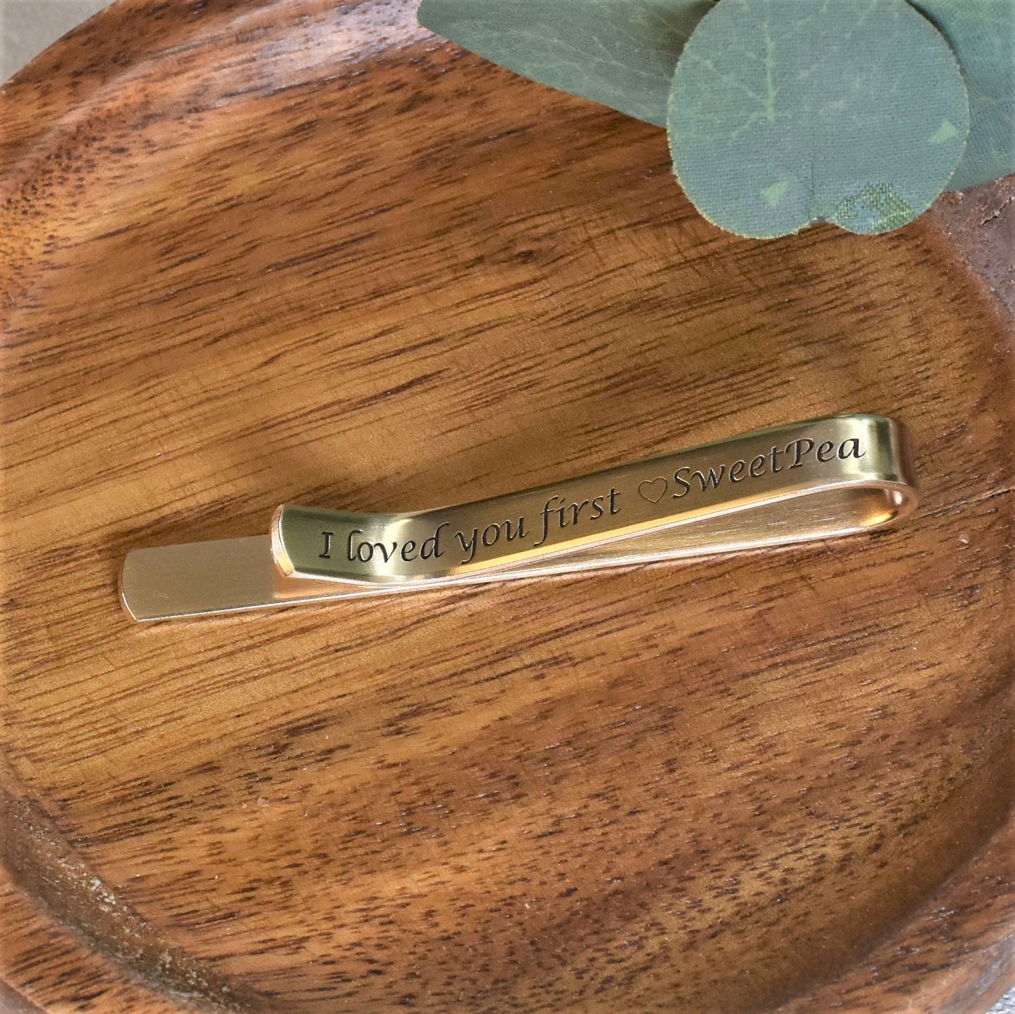 Personalized 2.5 inch long tie clip in gold brass metal.  Featuring engraved calligraphy font, satin finish and blackened text.
