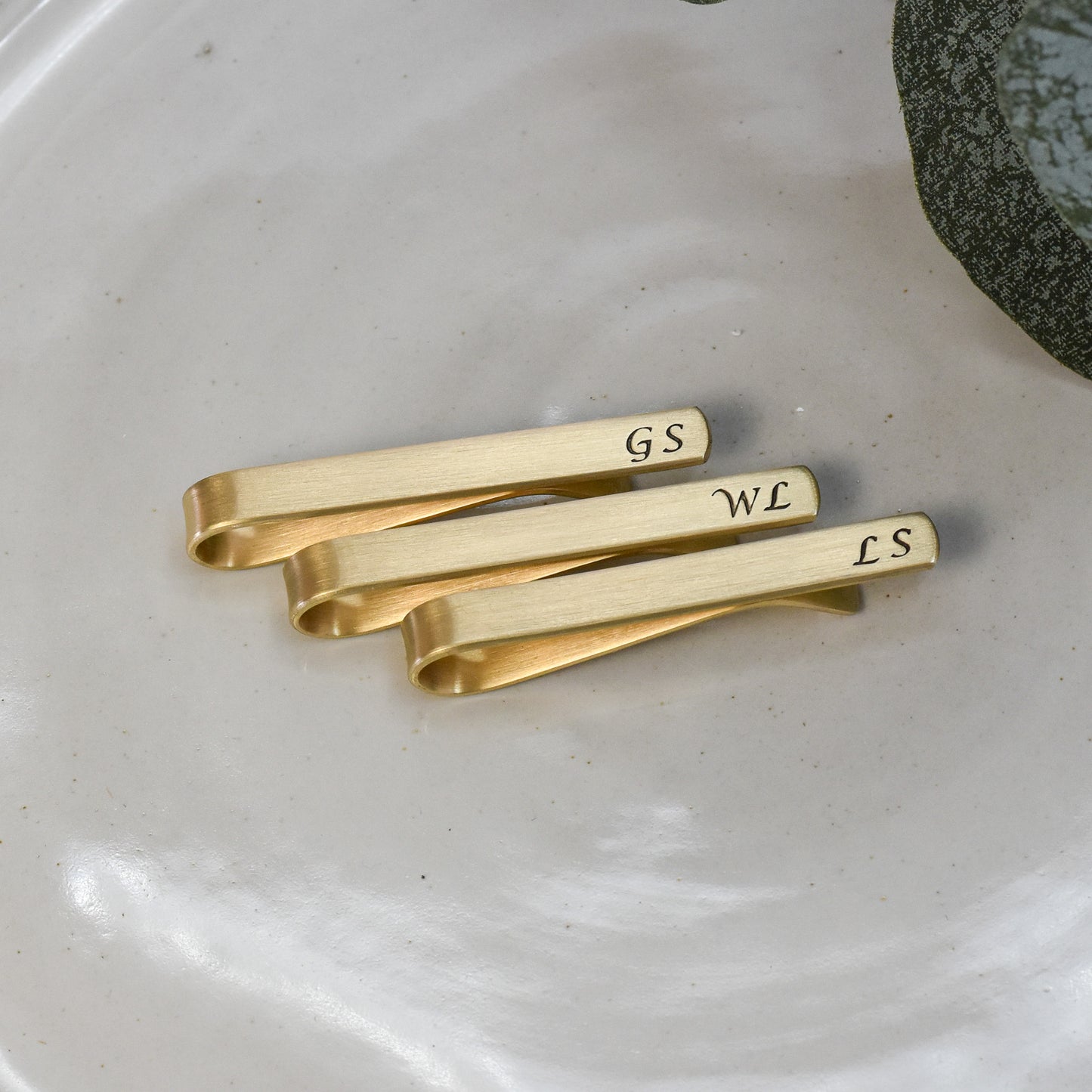Custom 2 inch standard size tie bar with personalized initials in calligraphy font. Matte finish and blackened text.