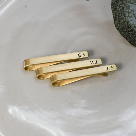 Custom 2 inch standard size tie bar with personalized initials in calligraphy font.  Matte finish and blackened text.