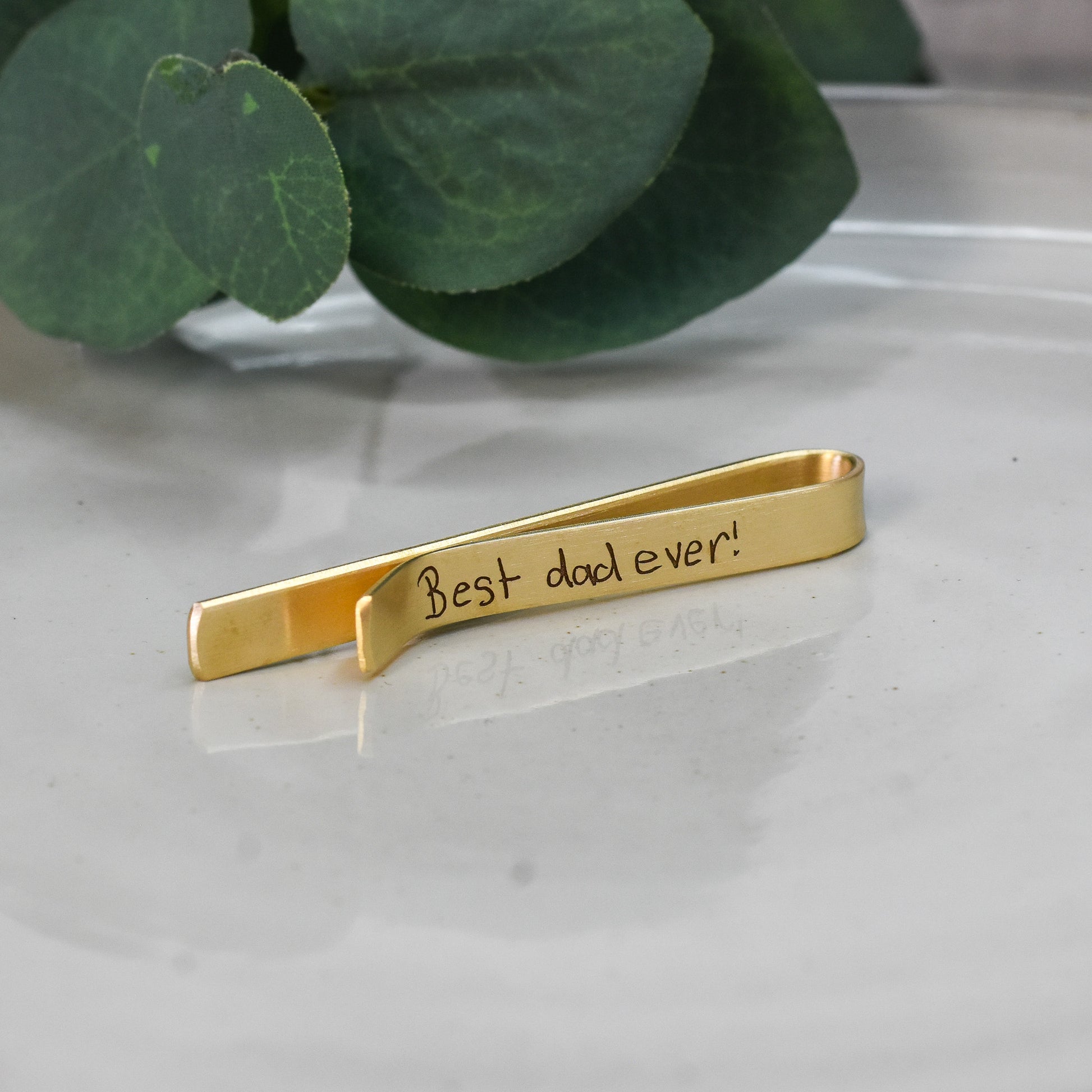 Gold tie bar engraved with handwritten message 