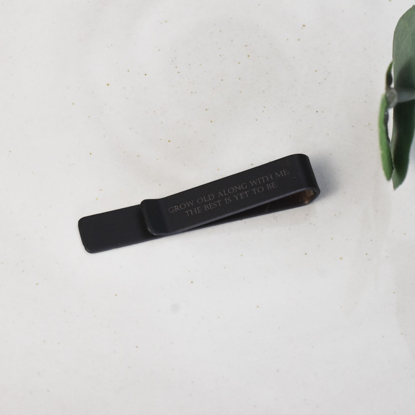 Custom engraved black tie bar with text in back hidden when worn on tie for personal message.
