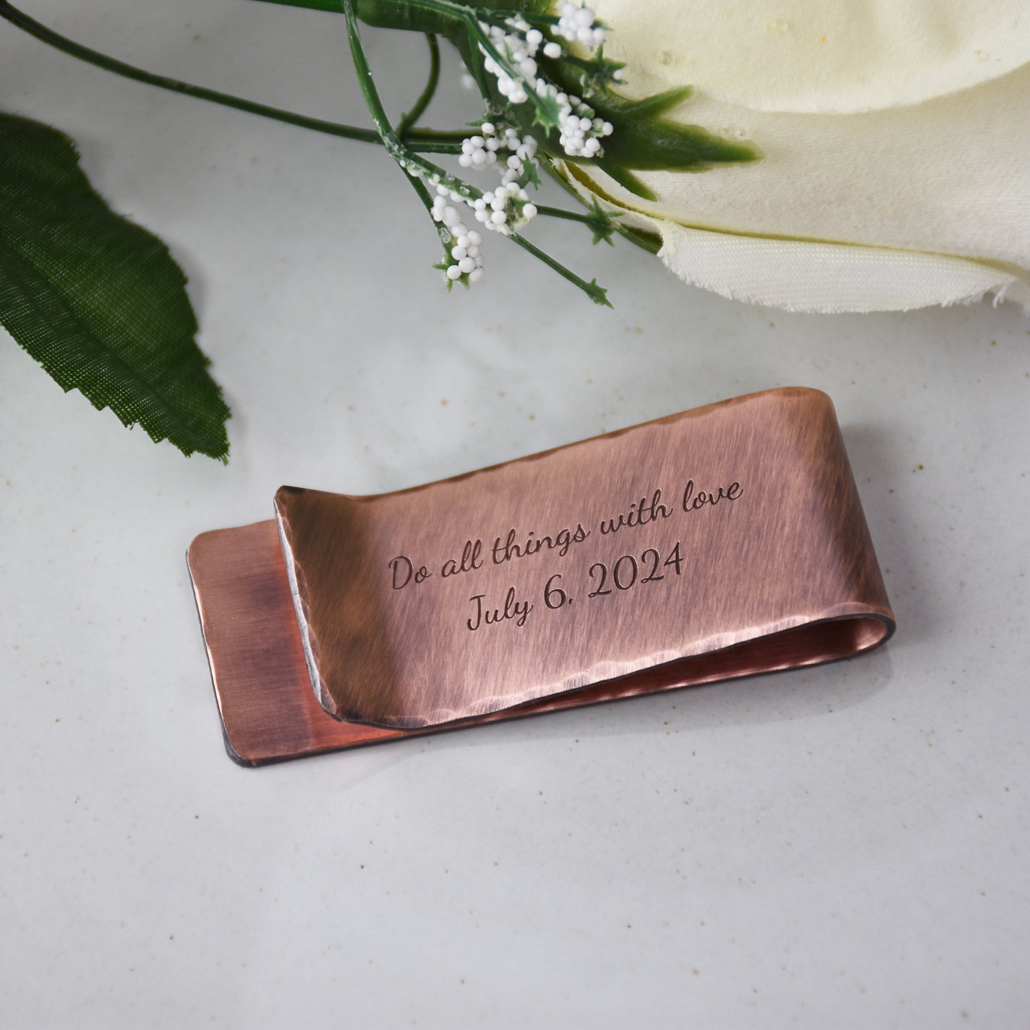 Photo of custom engraved copper metal money clip with the words "Do all things with love - July 6, 2024" handmade by 321 Simple Creations.