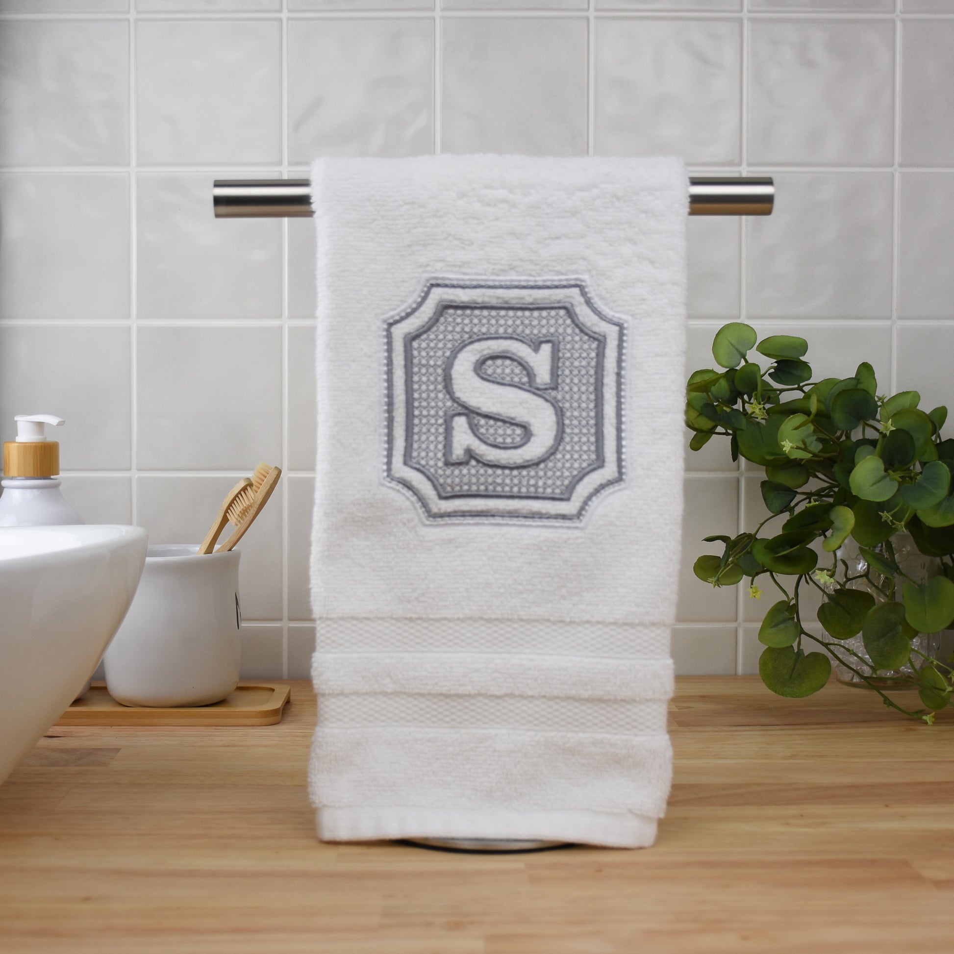 Custom embroidered plush hand towel in white with embossed grey monogram for bathroom