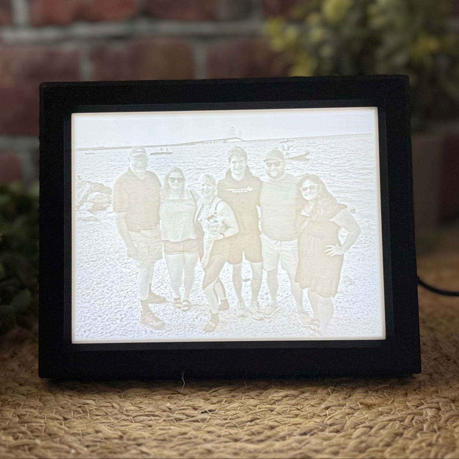 A 3D printed LED lit lithophane picture in a frame, displaying a silhouette of a family.
