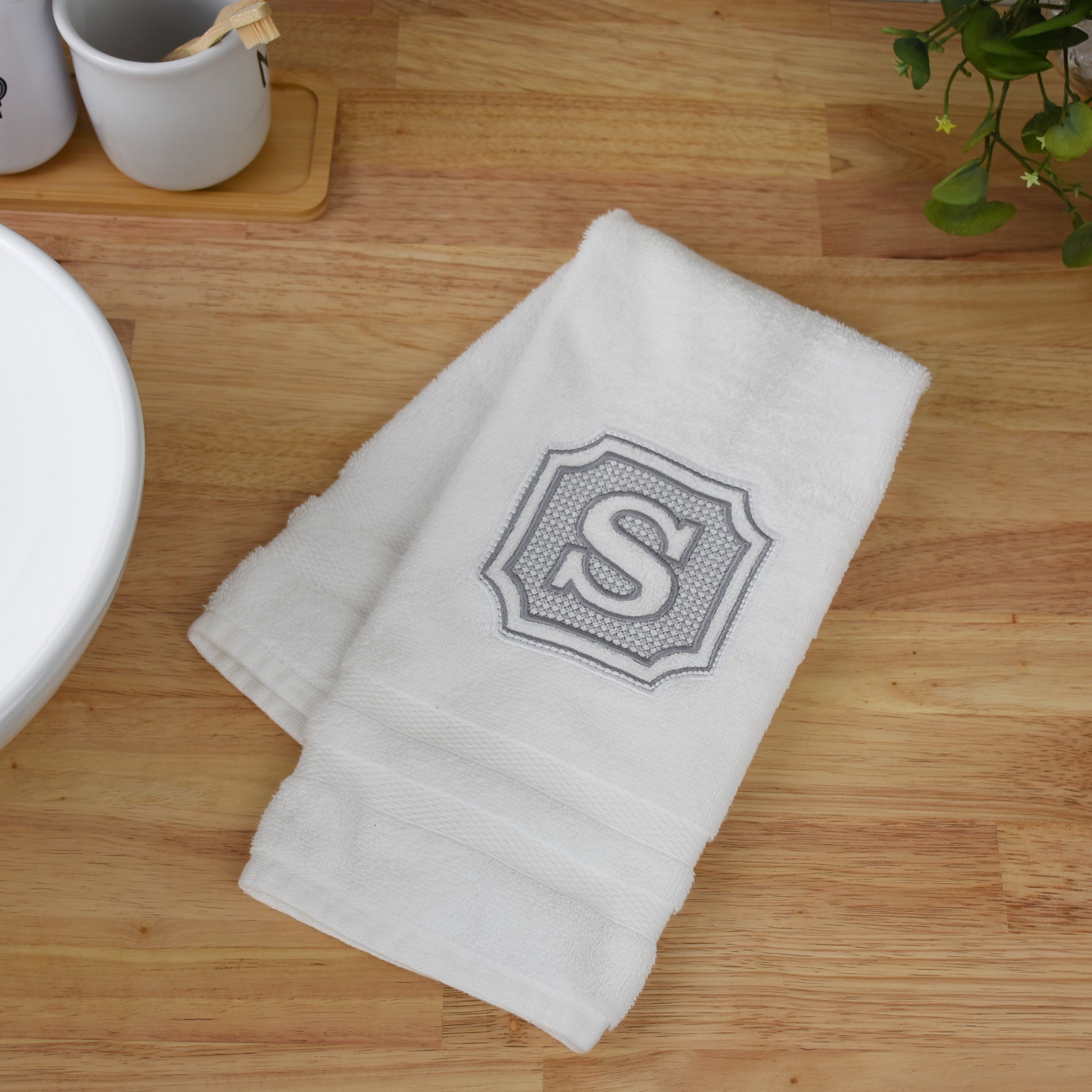 custom embroidered hand towel on butcher block countertop